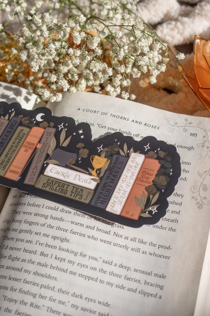 ACOTAR Funny Feyre Bookshelf Bookmark from A Court of Thorns and Roses by Sarah J Maas. A Bookshelf in earth tones like deep greens, browns and charcoal with a cauldron and a "snowball fight champion" trophy with book titles like "Reasons Tamlin is a lil bitch", "A Gardeners guide to strictly inedible plants", "Prison Breaks 101" and more.