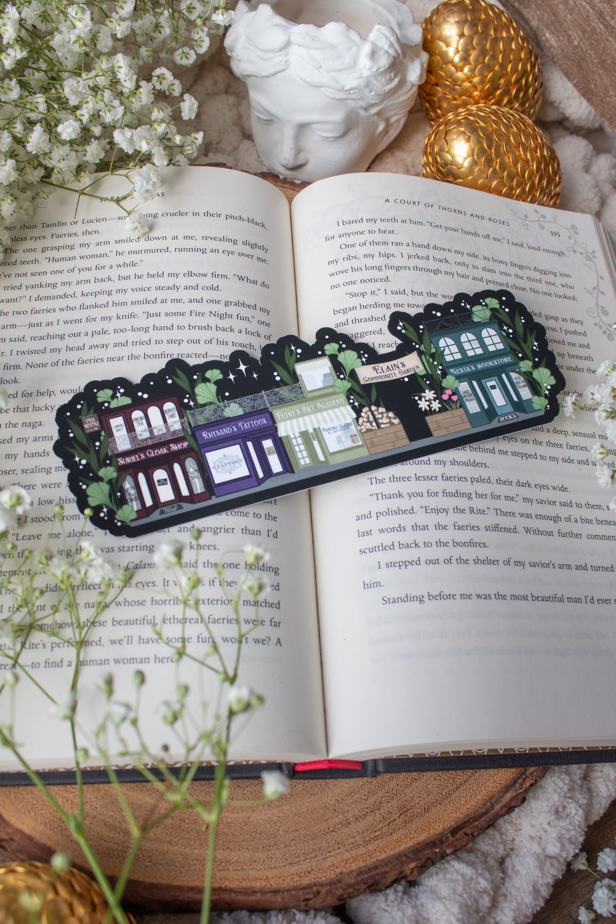 ACOTAR A Walk in Velaris Bookmark is an imagined velaris scene with fake shops like Nesta's bookstore, Elain's community garden (with only flowers in it), Feyre's Art Academy, Rhysand's Tattoo Parlor, and the Suriels Cloak Shop/ Tea Room. Inspired from A Court of Mist and Fury by Sarah J. Maas.