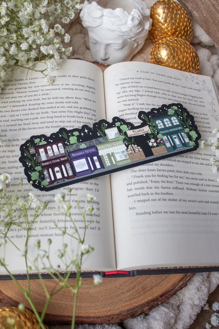 ACOTAR A Walk in Velaris Bookmark is an imagined velaris scene with fake shops like Nesta's bookstore, Elain's community garden (with only flowers in it), Feyre's Art Academy, Rhysand's Tattoo Parlor, and the Suriels Cloak Shop/ Tea Room. Inspired from A Court of Mist and Fury by Sarah J. Maas.