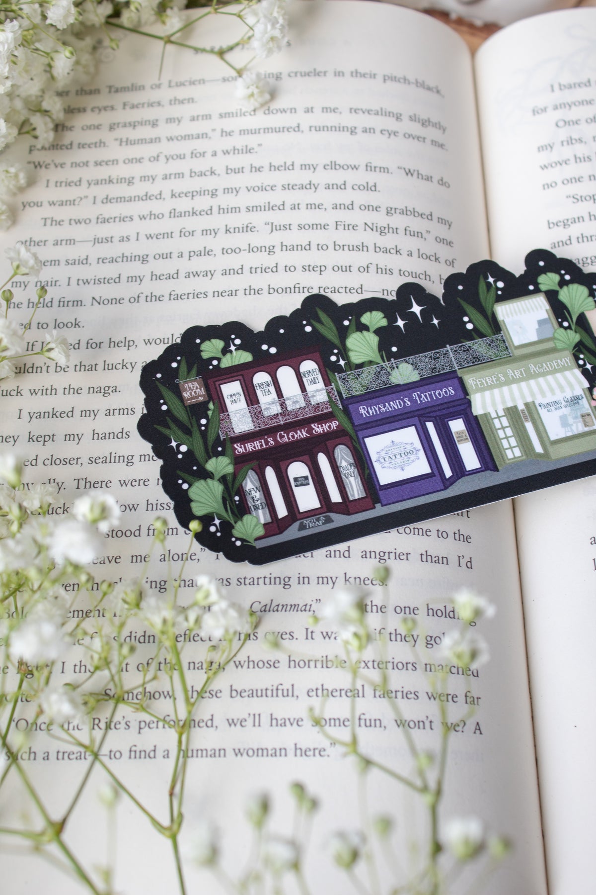 ACOTAR A Walk in Velaris Bookmark is an imagined velaris scene with fake shops like Nesta's bookstore, Elain's community garden (with only flowers in it), Feyre's Art Academy, Rhysand's Tattoo Parlor, and the Suriels Cloak Shop/ Tea Room. Inspired from A Court of Mist and Fury by Sarah J. Maas.