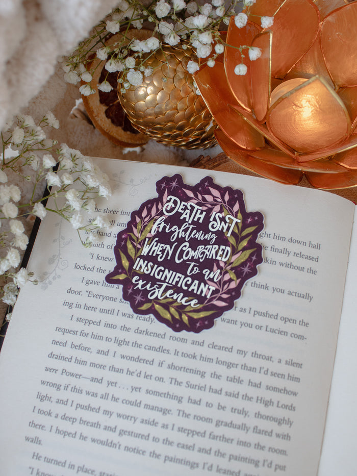 This officially licensed Serpent and the Wings of Night Sticker features the text "Death isn't frightening when compared to an insignificant existence" in cream text on a deep maroon background surrounded by pink and green foliage, little stars and magic bubbles.