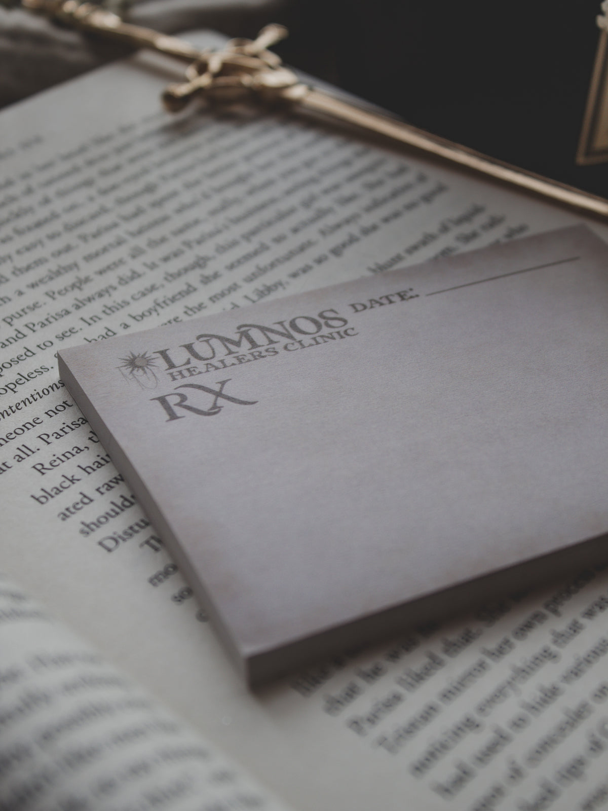 Spark of The Everflame Lumnos Healers Clinic RX Notepad. Inspired by the Kindreds Curse Saga by Penn Cole. This licensed 3"x4" post-it notepad looks like aged parchment, and has "Lumnos Healers Clinic - RX"  and a date line along the top then its signed off by Diem on the bottom corner.