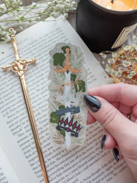 Spark of The Everflame Diem's Crown Sword Sticker, Lunmos Crown, Montios Crown, Fortos Crown, Umbros Crown. From The Kindred's Curse Saga by Penn Cole. This officially licensed sticker is a sword on a light tan background, through the forementioned crowns. Surrounded by foliage.