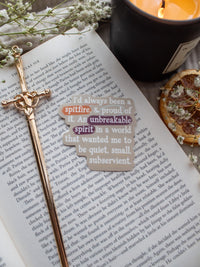 Spark of The Everflame "I'd always been a spitfire, and proud of it. An unbreakable spirit in a world that wanted me to be quiet, small, subservient." quote. Inspired from the novel from The Kindred's Curse Saga by Penn Cole, this officially licensed sticker has a camel background, with white type-writer style text and annotation like highlighting, circling, and underlining.