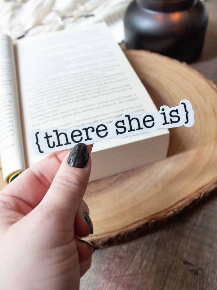 This There She Is sticker from The Serpent and The Wings of Night from the Crowns of Nyaxia Series by Carissa Broadbent is officially licensed. It features the text {there she is} in black on a solid white background