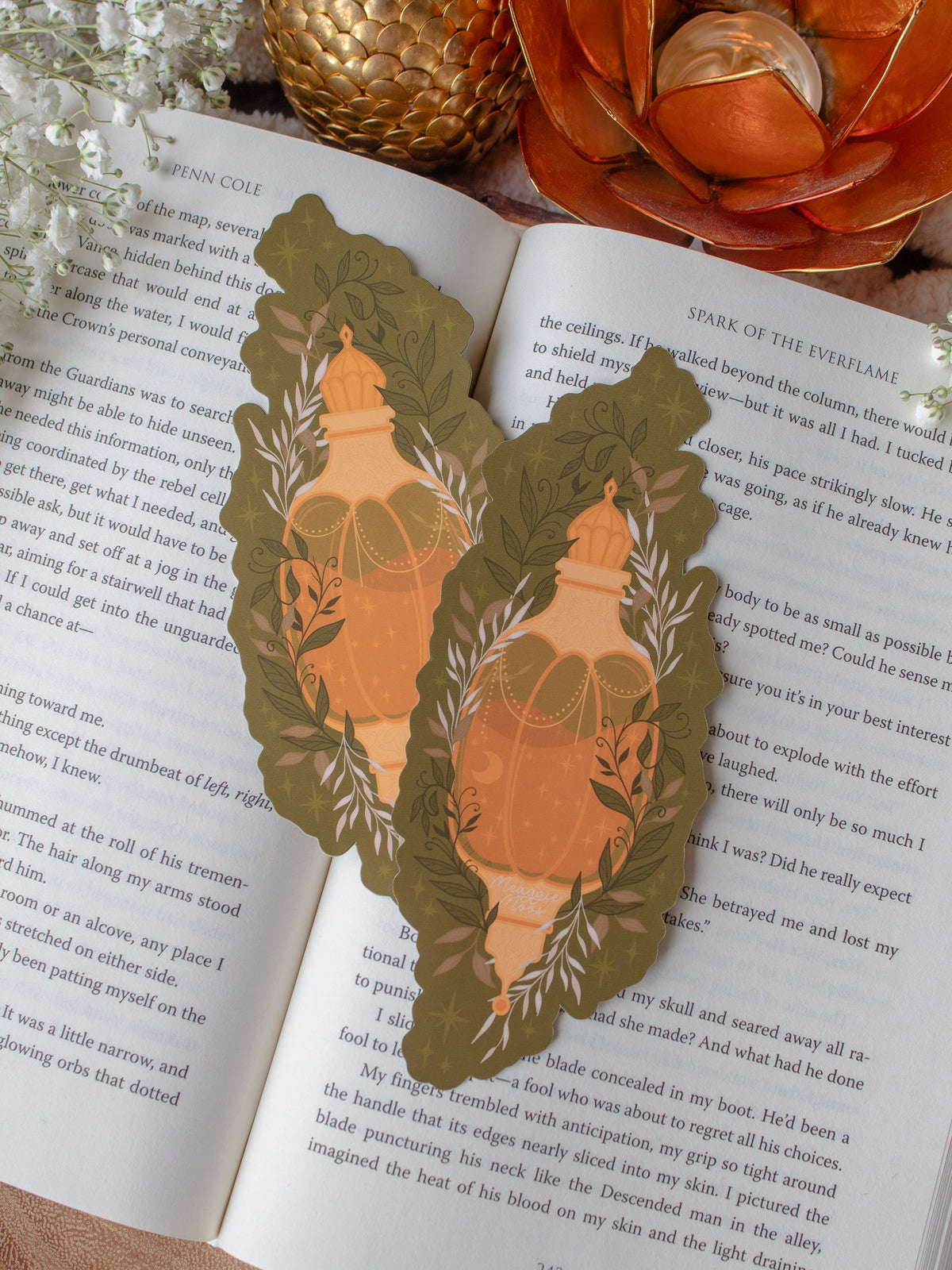 This fall autumn fantasy pumpkin spice potion bookmark features a pumpkin shaped potion bottle, in orange and yellow/gold on a deep green background with curling foliage, stars and magic bubbles surrounding it. 