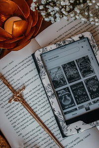 Ivory Swords Fantasy Reader Dragon Kindle Case. It has an ivory background with deep charcoal dragons, swords, crowns, and foliage all over it. This is a full cover kindle case with a leatherette outside, a kick-stand, card-slot, and hand-strap. 