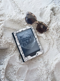 Ivory Swords Fantasy Reader Dragon Kindle Case. It has an ivory background with deep charcoal dragons, swords, crowns, and foliage all over it. This is a full cover kindle case with a leatherette outside, a kick-stand, card-slot, and hand-strap. 