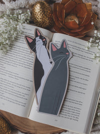Little Grey Kitty Cat Die-Cut Bookmark and the Black & White Kitty Cat bookmark on a book with baby's breath and other decorative elements around it. This one has a matte filter lol