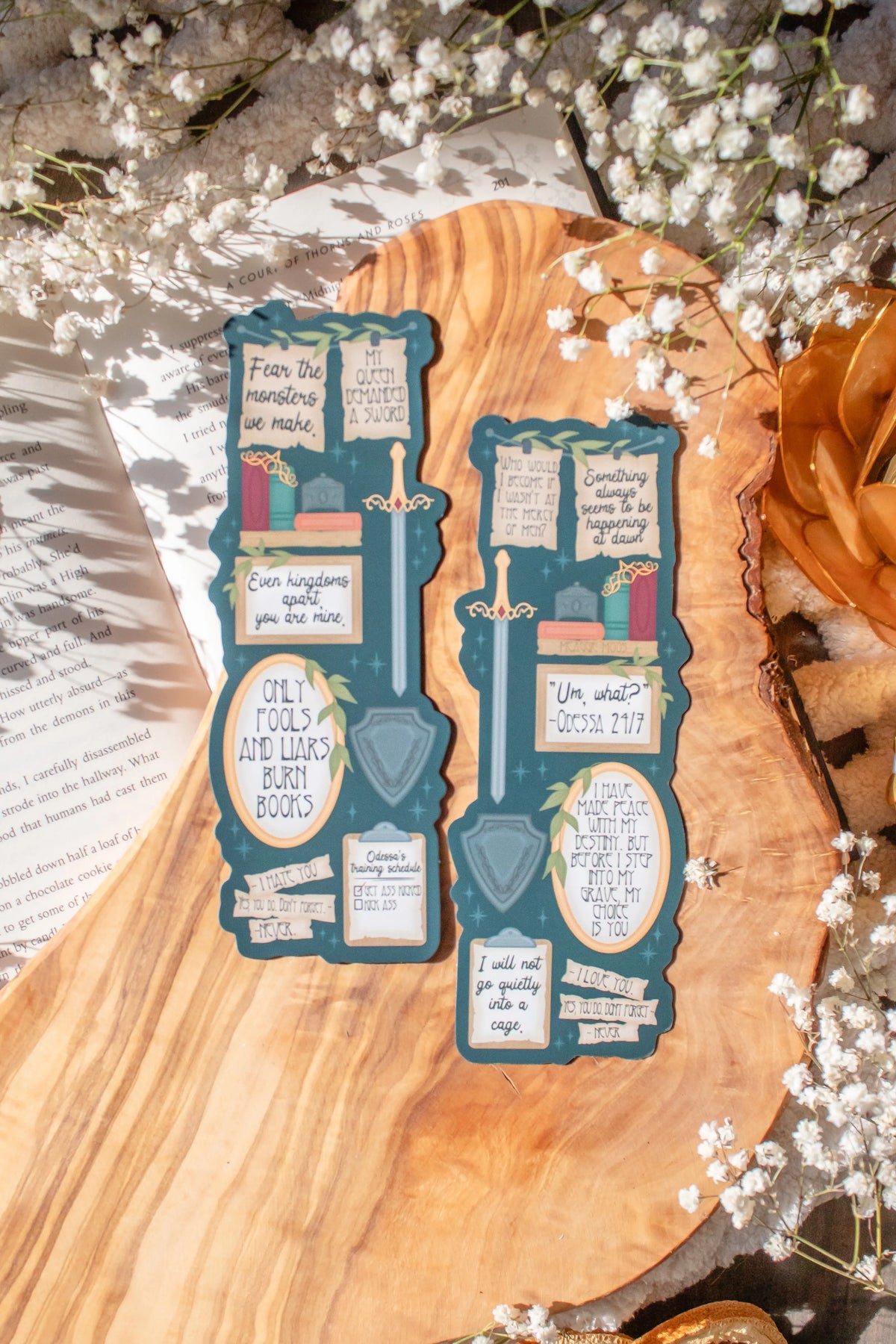 Bookmark inspired by the novel by Devney Perry. This bookmark is dark teal with frames on it with a bunch of different quotes from the book.

The bookmark is laid on an olive wood cutting board, sitting on an open book with little white flowers surrounding it.