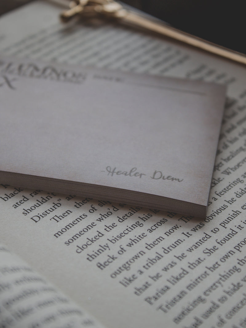 Spark of The Everflame Lumnos Healers Clinic RX Notepad. Inspired by the Kindreds Curse Saga by Penn Cole. This licensed 3"x4" post-it notepad looks like aged parchment, and has "Lumnos Healers Clinic - RX"  and a date line along the top then its signed off by Diem on the bottom corner.  