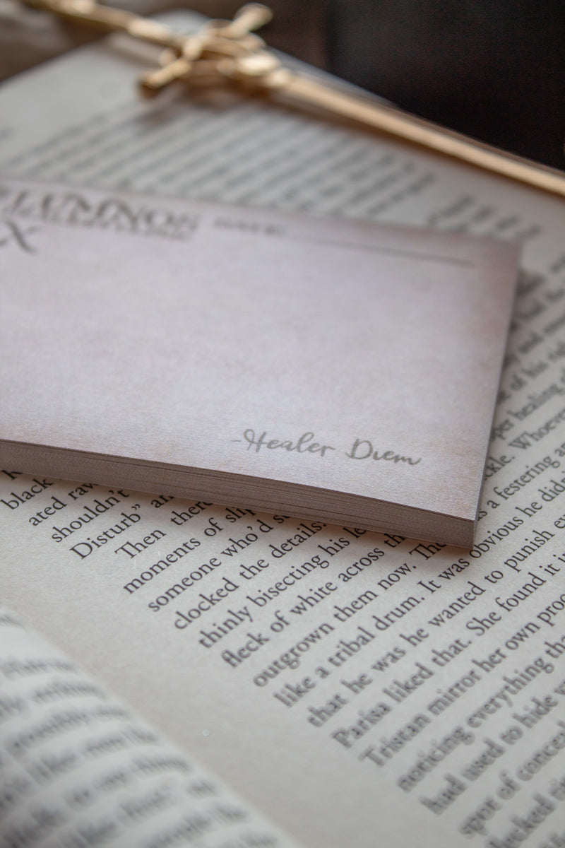 Spark of The Everflame Lumnos Healers Clinic RX Notepad. Inspired by the Kindreds Curse Saga by Penn Cole. This licensed 3"x4" post-it notepad looks like aged parchment, and has "Lumnos Healers Clinic - RX"  and a date line along the top then its signed off by Diem on the bottom corner.  