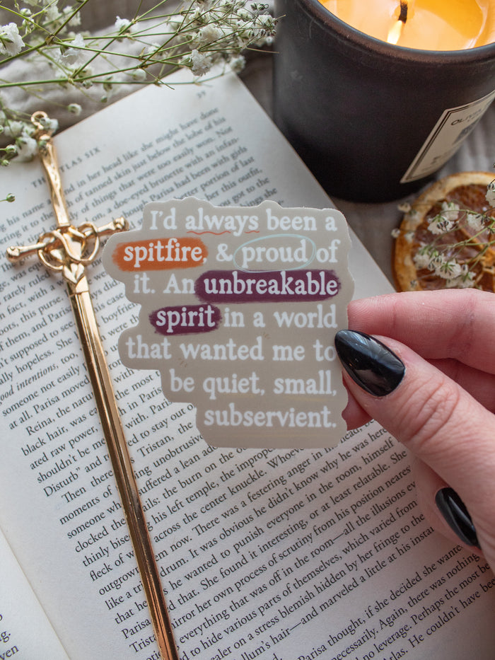 Spark of The Everflame "I'd always been a spitfire, and proud of it. An unbreakable spirit in a world that wanted me to be quiet, small, subservient." quote. Inspired from the novel from The Kindred's Curse Saga by Penn Cole, this officially licensed sticker has a camel background, with white type-writer style text and annotation like highlighting, circling, and underlining. 