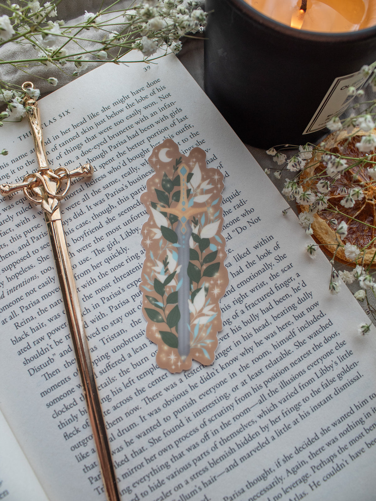 Spark of the Everflame Sword of Corbois waterproof and dishwasher safe vinyl sticker. From the Kindred's Curse Saga by Penn Cole. This officially licensed sticker is a dark metal sword, surrounded by foliage, on a burn orange background. 