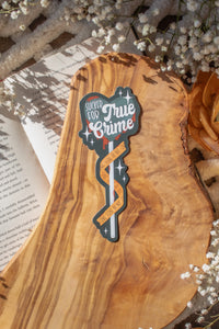 This Sucker for True Crime Die-Cut Bookmark is for all my mystery loving book babes who love to delve into a good cold case file. 

It is a dark grey heart shaped sucker with blood dripping off of it, wrapped in crime scene tape and surrounded by stars on a darker grey background.


The bookmark is sitting on an olive wood cutting board, on an open book, with little white flowers surrounding it.