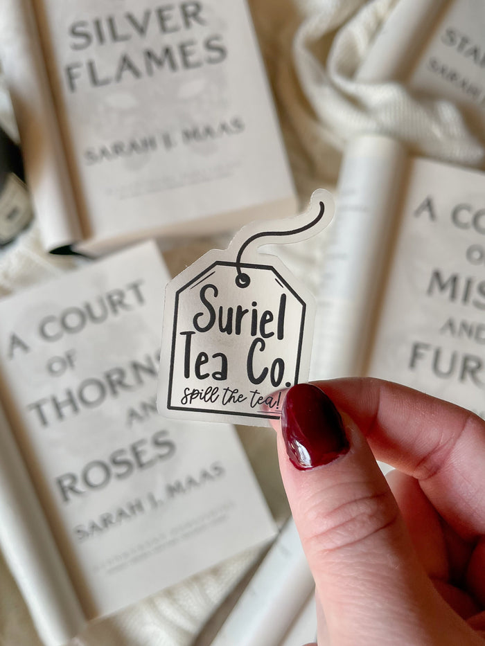 This little Suriel Tea Co Tea Bag Sticker from A Court of Thorns and Roses by Sarah J Maas is perfect for any ACOTAR Fan to show off their love of the series in a subtle way. It is all black on a clear background and it looks like a small tea bag with the text "Suriel Tea Co - Spill the Tea!" on it. 