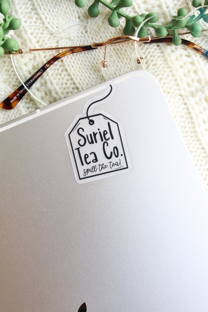 This little Suriel Tea Co Tea Bag Sticker from A Court of Thorns and Roses by Sarah J Maas is perfect for any ACOTAR Fan to show off their love of the series in a subtle way. It is all black on a clear background and it looks like a small tea bag with the text "Suriel Tea Co - Spill the Tea!" on it. 