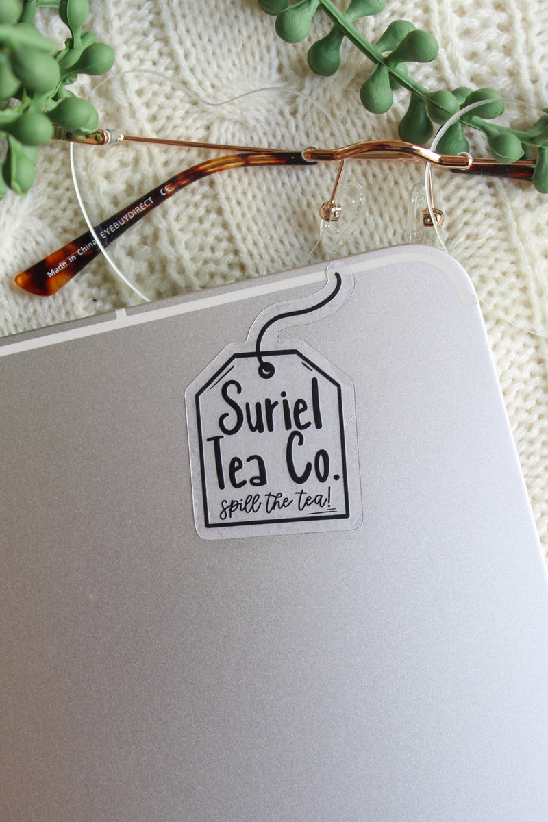 This little Suriel Tea Co Tea Bag Sticker from A Court of Thorns and Roses by Sarah J Maas is perfect for any ACOTAR Fan to show off their love of the series in a subtle way. It is all black on a clear background and it looks like a small tea bag with the text "Suriel Tea Co - Spill the Tea!" on it. 