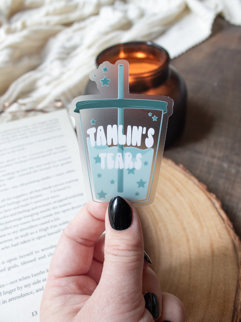 This ACOTAR Tamlin's Tears Tumbler Sticker from A Court of Thorns and Roses by Sarah J Maas is a light blue/ teal tumbler with the text "Tamlin's Tears" in a white bubble font. Transparent Background. 
