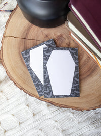 This Halloween Spooky Post-It Notepad is 3"x4" and features an unlined coffin design surrounded by lil bats. 