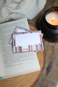 These bookshelf post-it notepads show a bookcase with a white box over them, with some books peeking over. 